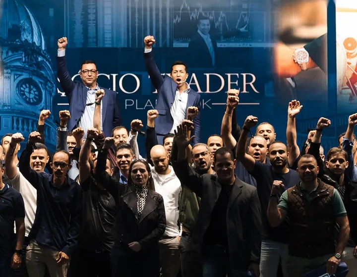 Ariel Fernandes no palco do evento Sócio Trader, de punho erguido junto com os alunos